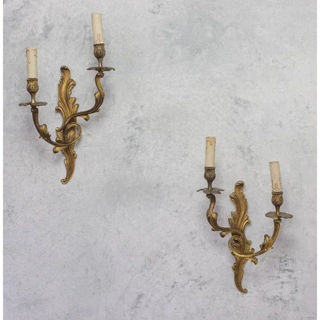 Elegant pair of French 1920s gilt bronze sconces with two arms in the Louis XV style. Very good vintage condition, but...