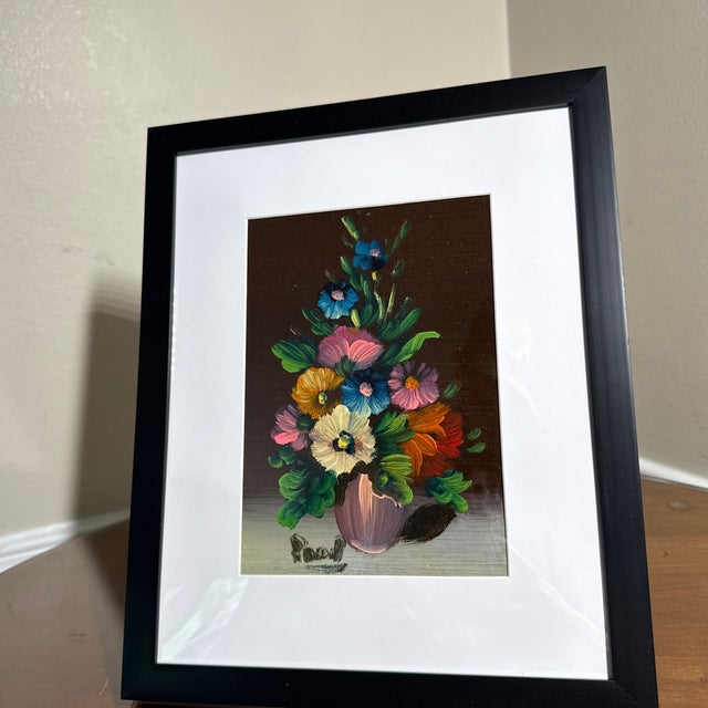 Beautiful vintage floral still life painting featuring a vibrant bouquet of multicolored flowers arranged in a decorative...