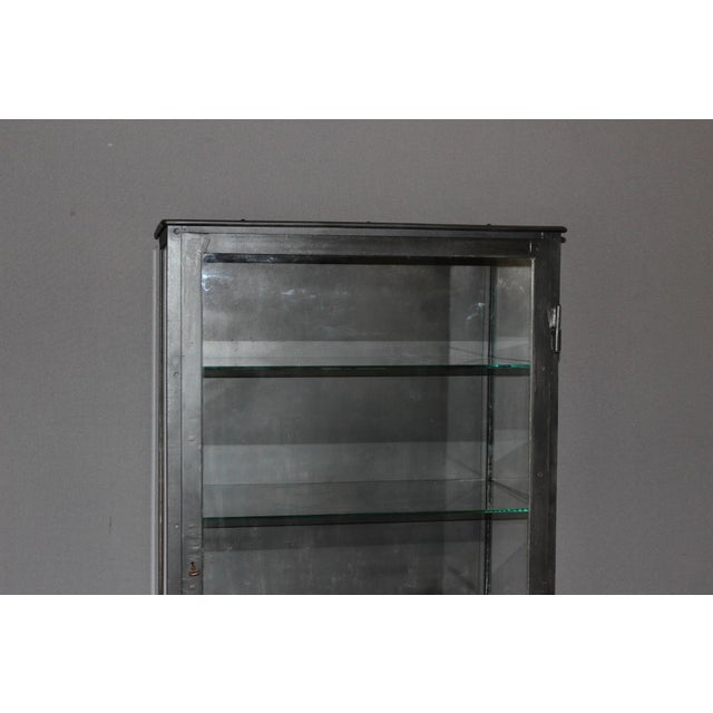 Iron display cabinet with a black patina, glazed on three sides, opens with a door, four fixed glass shelves, interior...