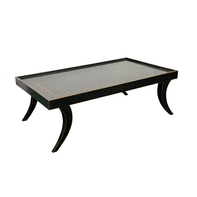 This elegant, low-profile coffee table features a striking black lacquer finish paired with understated, refined...