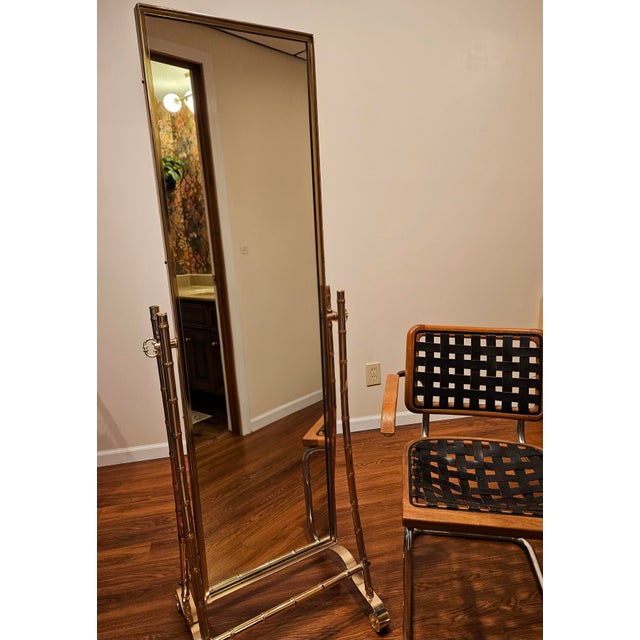 Offered is an exceptional, collector grade mid-century modern faux bamboo cheval floor mirror by the renowned metalwork...