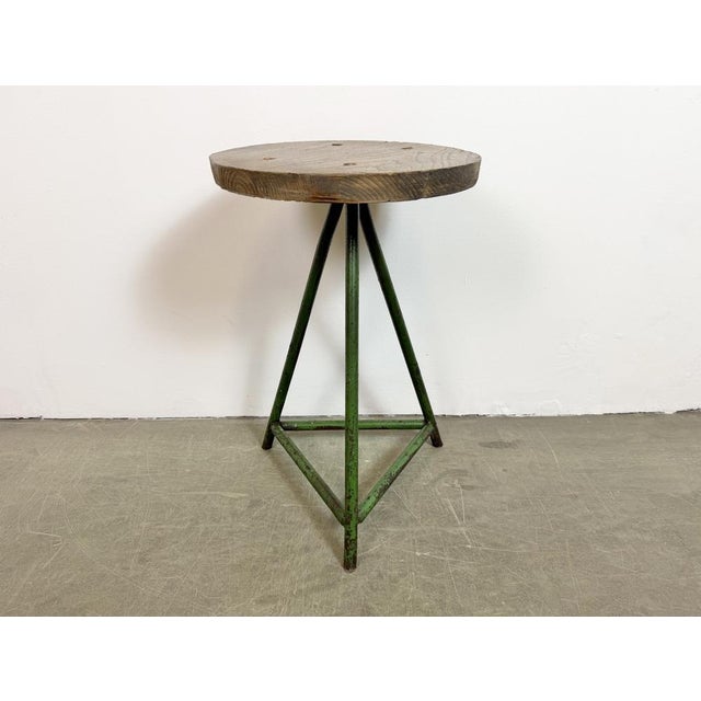 Vintage Industrial factory stool made in former Czechoslovakia during the 1960s It features a wooden seat and a green iron...