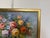 This original oil on canvas painting presents a lush and expressive floral still life, centered around a softly rounded...