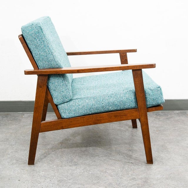 Mid century modern arm chair in solid wood and upholstered in a aqua blue fabric. Wood arms on either side. outstanding...