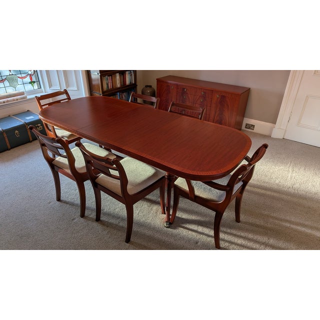 Vintage E.S.A. McIntosh mahogany extendable dining table with 6 upholstered chairs. The twin-pedestal base with splayed...