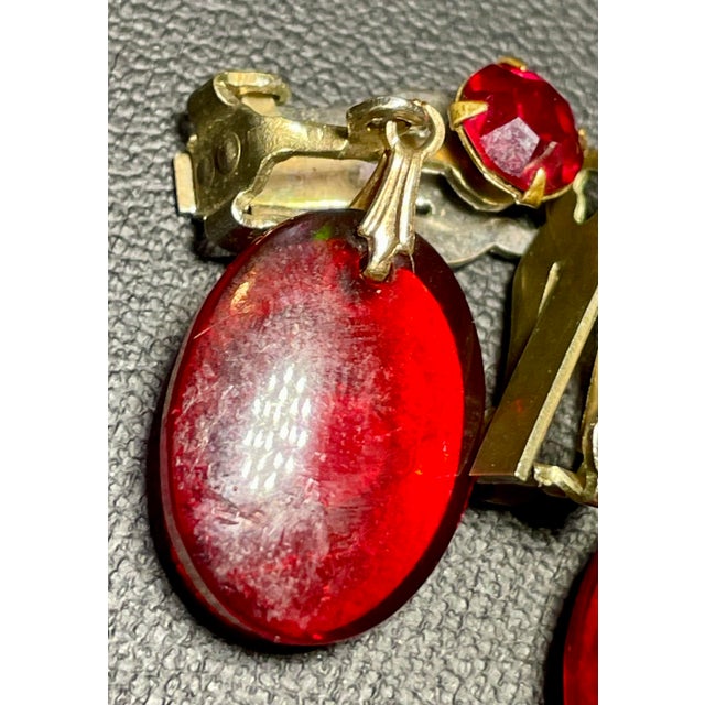 Set molded ruby red translucent lucite cameos in antique gold-tone setting with Victorian silhouette and side-mounted...
