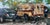 Holy Ghost and Neighbors by Clyde Steadman | Oil Painting of a parked camper and cars in a lot For Sale