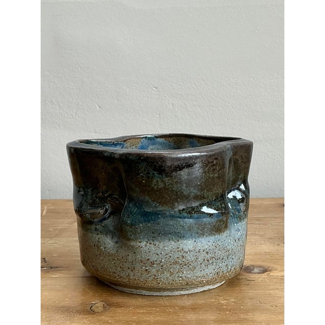 This evocative vintage studio pottery bowl is a masterclass in organic form and tactile design. Hand-thrown and then...