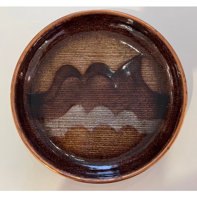 An original hand made enamel over copper low bowl with wave earth tone decorative design. Signed by the famed designer...