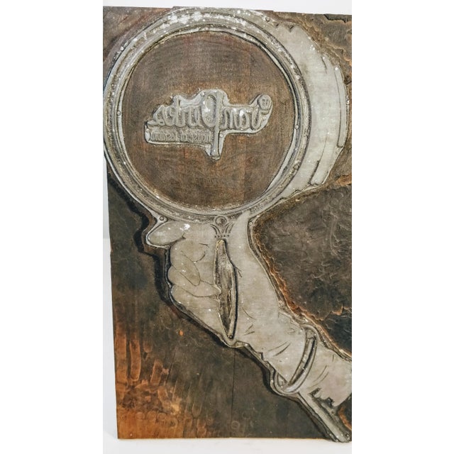 This extra-large wooden printer's ink block features a hand holding a magnifying glass, fashion mirror, showcasing a...