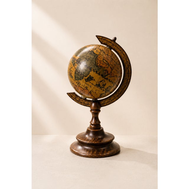 An elegant vintage decorative desktop globe of Italian origin, featuring a finely turned wooden base and a bronze finished...