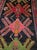 A captivating vintage Karabagh rug featuring an elegant deep black background embellished with four large polychrome...