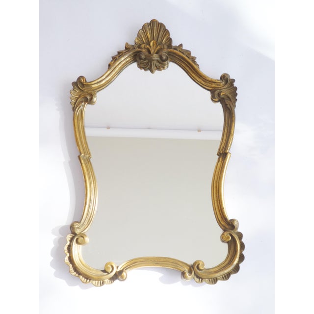 A stunning gold gilt scalloped French baroque style mirror from the 70's. It has a wonderful carved frame. The mirror is...