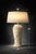 A large sculptural Palm Beach style table lamp featuring dramatic carved leaf relief and an oversized linen shade. With...