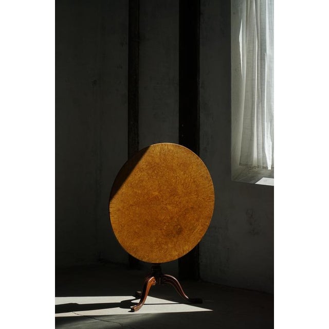 An elegant Swedish antique tilt-top occasional table crafted in richly figured burl wood veneer, dating to the mid-19th...
