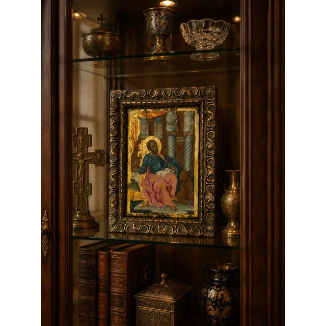 A beautifully executed Greek Orthodox icon depicting St. Luke the Evangelist, shown seated with his Gospel and accompanied...