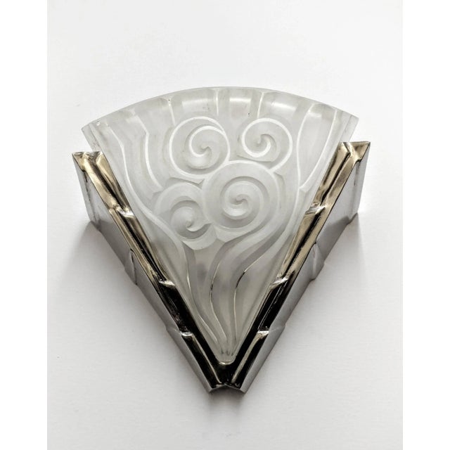 A pair of French Art Deco wall sconces by the French artist "David Gueron Degue" known as Degue. In a molded clear frosted...