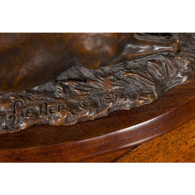 A cast bronze sculpture signed and dated Suzanne Fiedler 1974, depicting a horse and foal on wooden base. Cast by American...