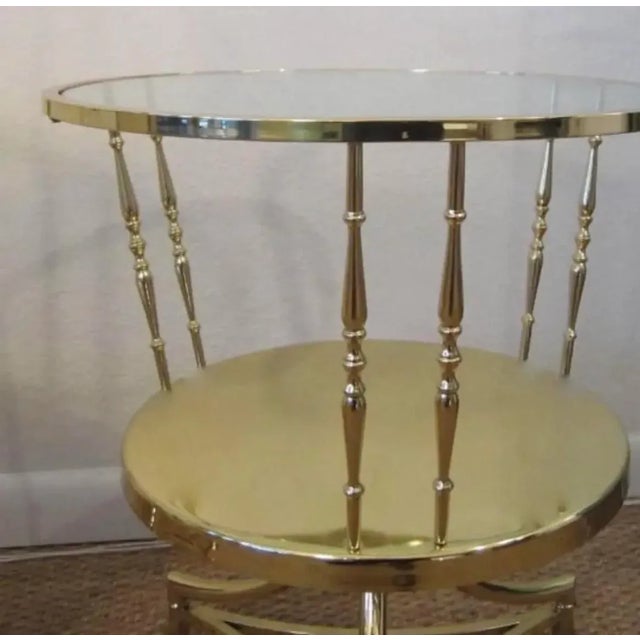 Pair of elegant Italian side tables made of brass and glass. They have two tiers each with spool-type brass columns...