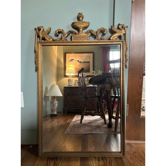 An exceptional turn-of-the-century Neoclassical revival gilt wall mirror, circa 1900. Features a hand-carved wood frame...