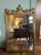 An exceptional turn-of-the-century Neoclassical revival gilt wall mirror, circa 1900. Features a hand-carved wood frame...
