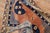 An early 20th century Khotan rug in salmon and navy blue hues part of a pair