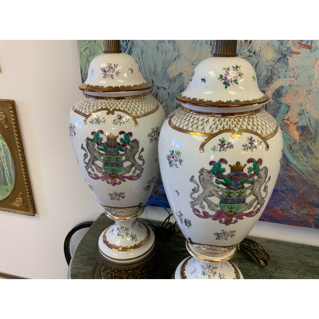 Pair of French porcelain Sanson Lamps. Armorial design, brass bass fittings. Base to top of socket measures 25.25”