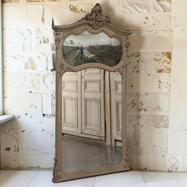 Celebrating the romance of the French countryside, this exceptional antique trumeau mirror combines hand-carved oak,...