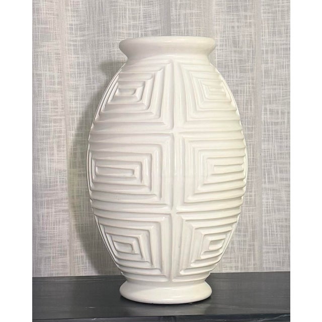 A substantial and architecturally scaled ceramic vase by Global Views, featuring a deeply carved geometric relief pattern...