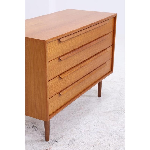 Vintage teak chest of drawers from WK Möbel with four spacious drawers and the characteristic long handles. The clean...
