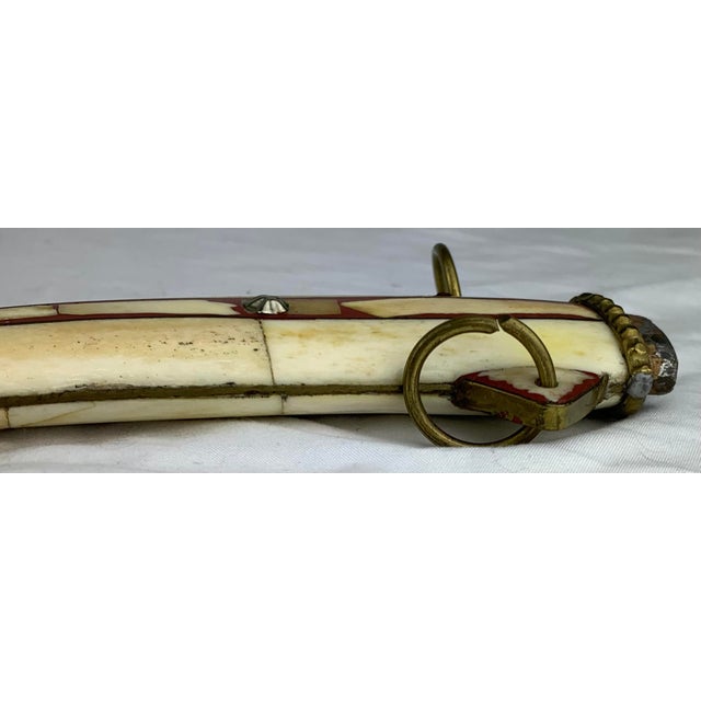 This is a traditional curved Moroccan dagger, often called a koummya or khanjar. The hilt and scabbard are distinctively...