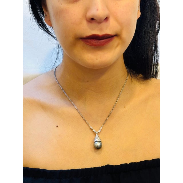 Introducing the exquisite 14 mm Black Tahitian Pearl & Diamond Pendant in 18K Gold, accompanied by a 14K Gold Chain. This...
