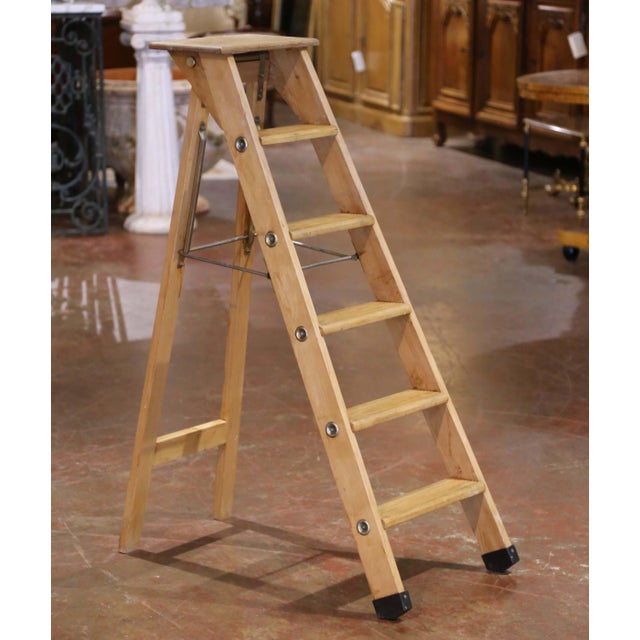 Crafted in France circa 1960, this antique six-step folding ladder blends rustic charm with mid century functionality....