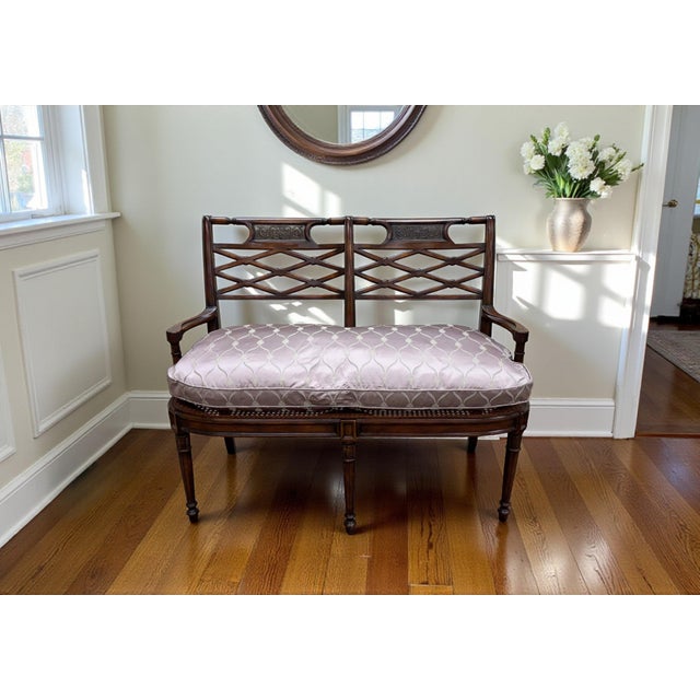 Theodore Alexander Regency Settee. Features a carved wood frame with a caned seat, fretwork back, hammered brass inserts,...