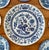 A classic blue and white wall plate layout with carefully collected vintage and antique plates. The center plate is...