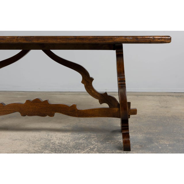 Late 19th century Spanish Renaissance Revival walnut trestle table, sourced in Provence, France. The rectangular top is...