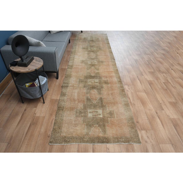 Vintage Hand-Knotted runner rug is a semi-antique vintage area rug. The '70s Eastern region of Anatolia's unique rug is...