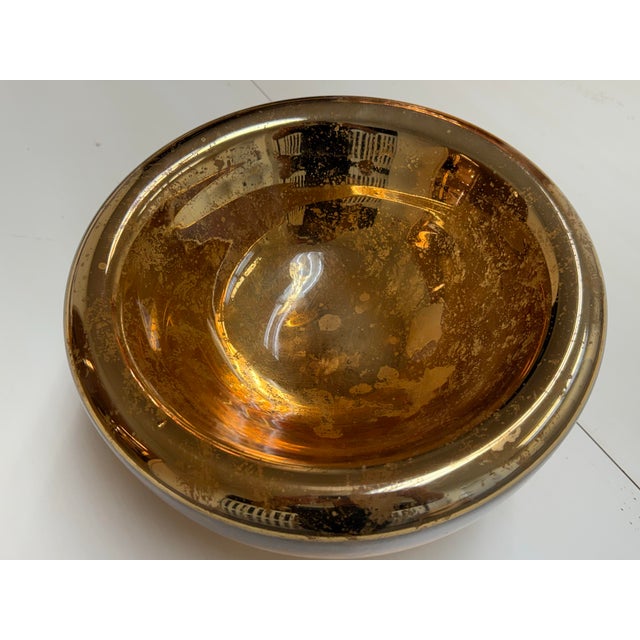 Design Plus Gallery presents an Amber Mercury Glass Decorative Bowl. The rounded glass form has a wide rolled rim,...