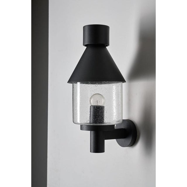 This outdoor wall lantern comes from the "Boom" collection by BEGA. Unlike BEGA's modern architectural lines, the Boom...