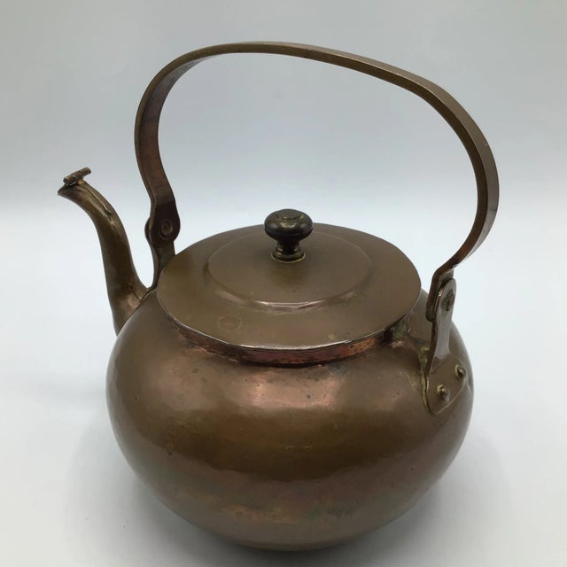Wonderful age with this hand made and hand hammered copper tea pot with hinged pour spout flapper. Nice thick strap handle...