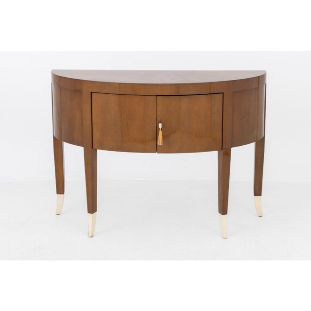 French Art Deco Style Demilune Cabinet, lacquered wood with two doors above tapered legs. 34.25" H x 47.5" W x 16" D....