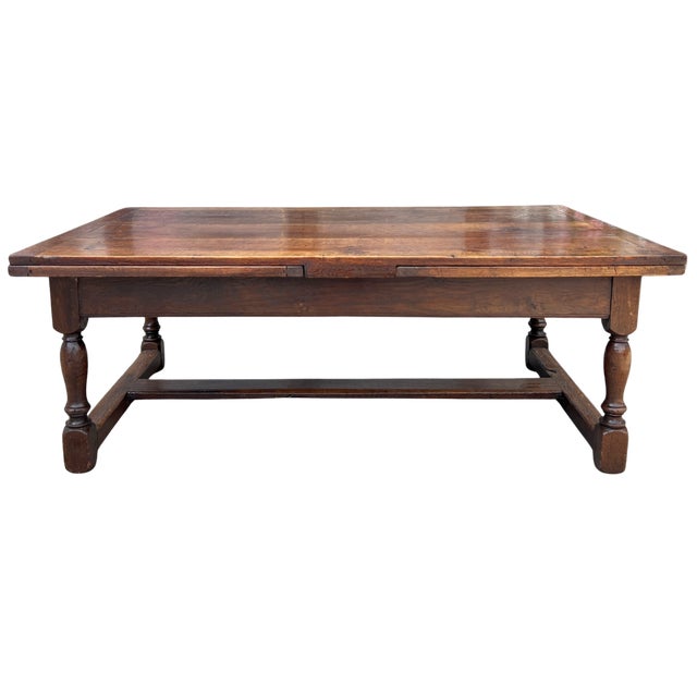 A handsome 19th-century English oak coffee table featuring a clever draw-leaf design that offers both versatility and...