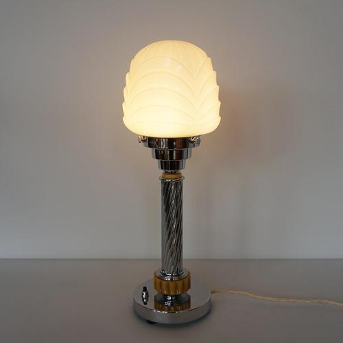 An Art Deco style table lamp. Ribbed amber bakelite with spiralled chrome stem and a white ridge globe H 42cm W 14cm...
