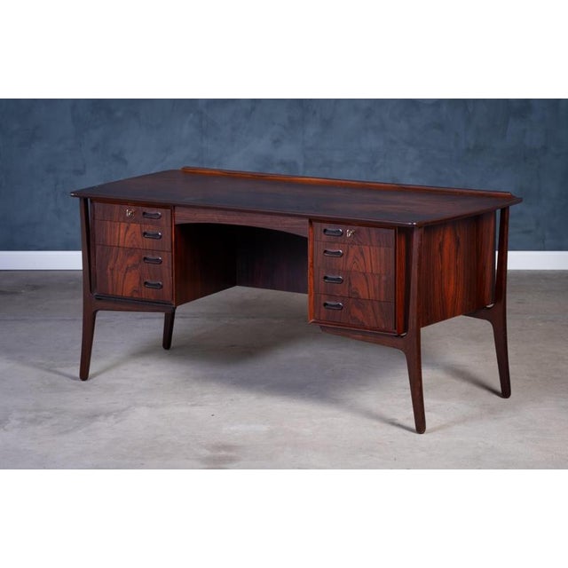 This stunning rosewood desk, designed by Svend Åge Madsen for H.P. Hansen in the 1960s, features exquisite craftsmanship...