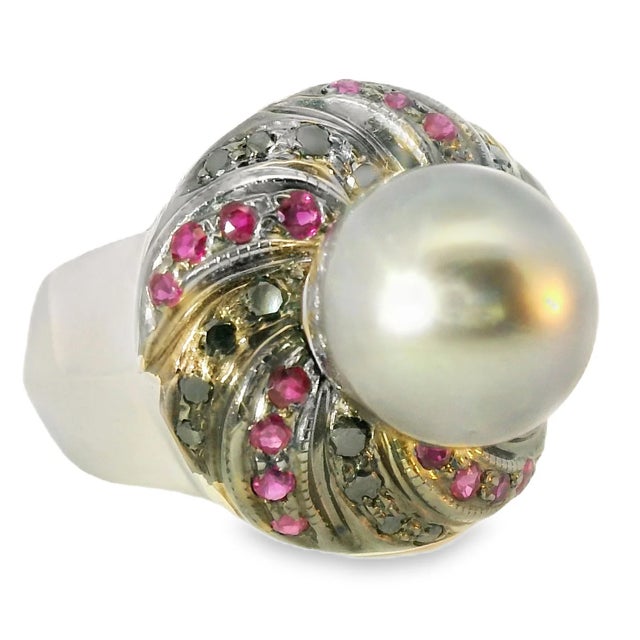 Striking estate 14K white gold ring featuring a 10 mm black pearl accented with black diamonds and natural rubies for a...