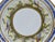 Finely decorated porcelain saucer, notable for its colorful and intricate hand-painted design. The rim is adorned with a...