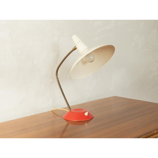 Classic table lamp by Louis Kalff from the 1950s. High-quality copper neck with a swiveling, cream-white metal lampshade...