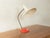Classic table lamp by Louis Kalff from the 1950s. High-quality copper neck with a swiveling, cream-white metal lampshade...