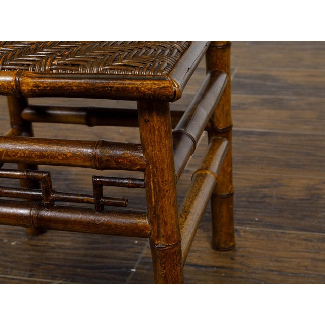 A small signed Perret et Vibert Chinoiserie bamboo chair from the late 19th century with mother of pearl inlaid black...