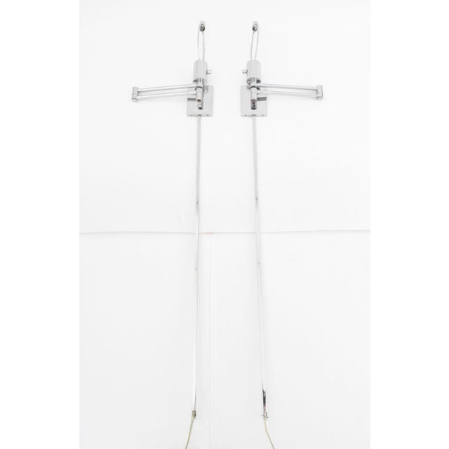 Pair of Hinson Lighting Chrome Swing-Arm Wall Lights, marked to wall attachment. Extended: 51" H x 20" W x 3.5" D....